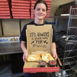 Person at Pizza Palace Wellington holding a pizza box