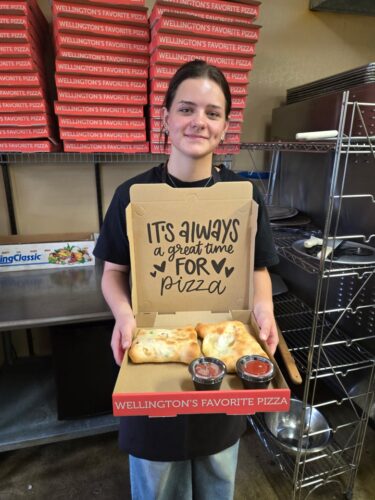 Person at Pizza Palace Wellington holding a pizza box